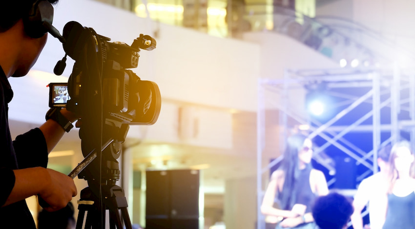 a production camera focuses on a talk show host at a live studio recording session in Los Angeles, California