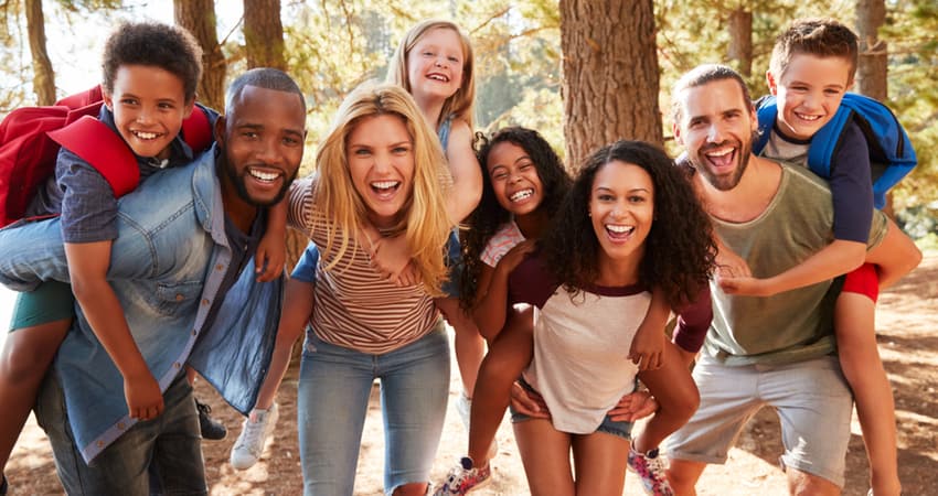 a multicultural group of people hiking with their children