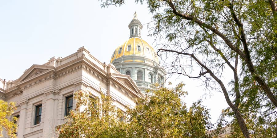 view of the golden dome of the Colorado State Capitol Building from the outside lawn