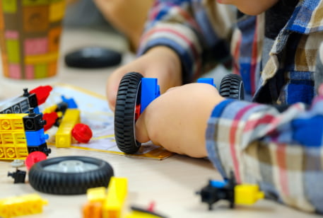 a child constructs a wheeled robot in a science museum