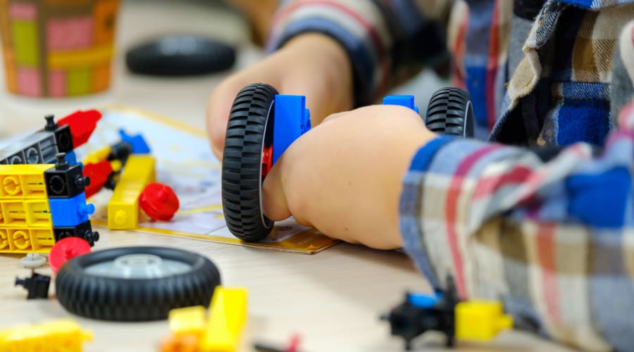 a child constructs a wheeled robot in a science museum