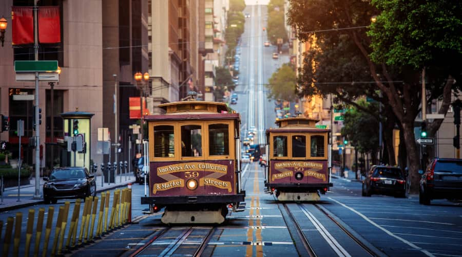 two San Francisco cable cars pass each other on a hilly street