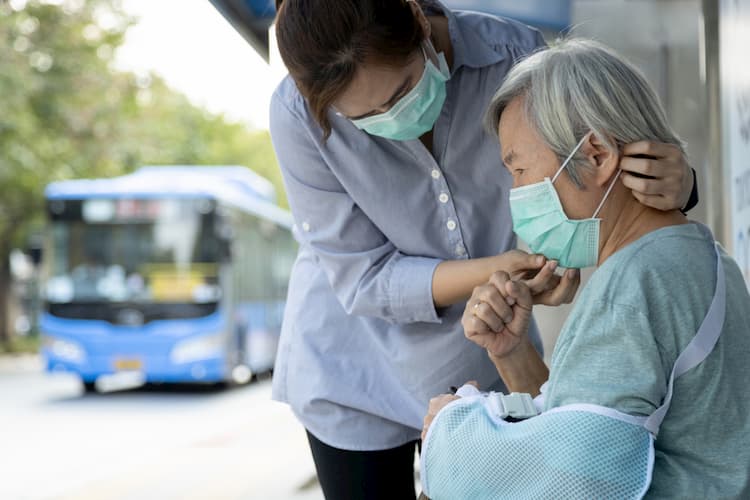 Woman helping mother with mask