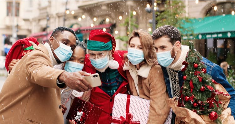 friends wearing masks outdoors in the snow pose for a selfie