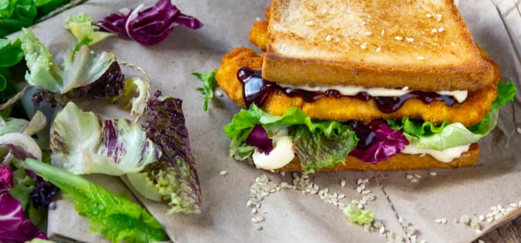 a grilled sandwich with colorful leafy greens