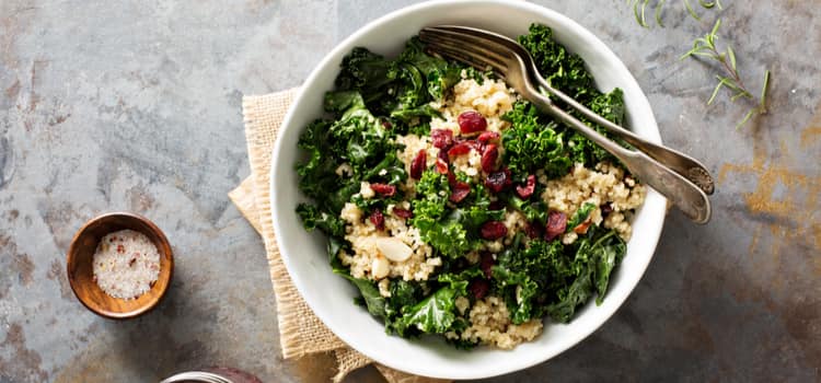 a kale salad with dried cranberries and nuts on top