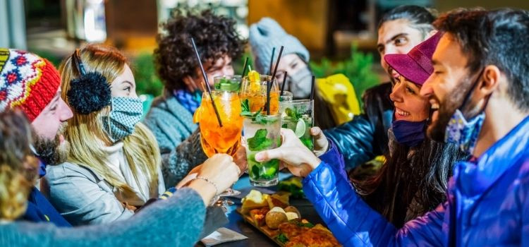 group clinking holiday drinks at a christmas party