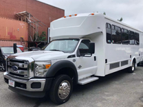 a plain white minibus with black windows parked next to a large building