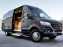 a small all-black minibus with its side door open